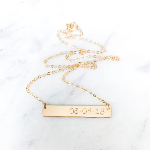 gold bar necklace with day, month, year stated in numerals