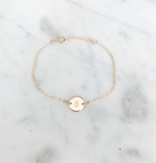 gold chain bracelet with monogram pendant in the middle